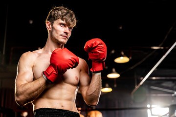 Boxing fighter shirtless posing, caucasian man boxer wearing red glove in defensive guard stance...