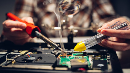 the master solders the chip with a soldering iron