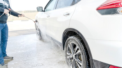 a man washes a car at a self-service car wash