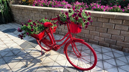 Red decorative bike in a green park on a sunny day