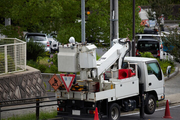 夏の街の道路で電線を整備している様子