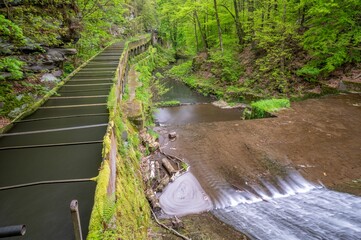 Picturesque waterfall cascading down a rocky cliff face surrounded by lush greenery