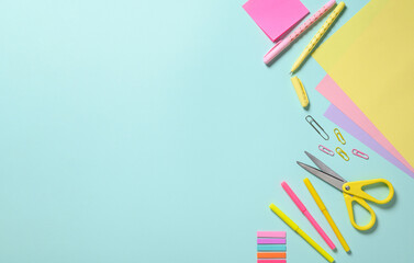 Various stationery items for creativity on a blue background. View from above,