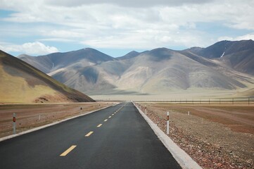 Idyllic landscape featuring an open road winding through a mountainous region
