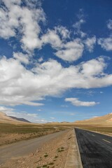 Aerial view of road through desert surrounded by hills