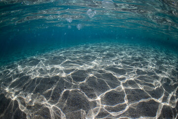 Beautiful water and light pattern on the underwater sand.