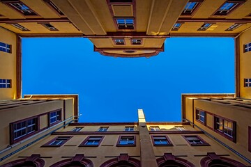 Low angle shot of an apartment building surrounded by a beautiful blue sky