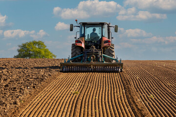 Agriculteur au volant de son tracteur pendant les semences au printemps.