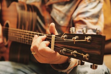 Closeup of a person playing a guitar at home