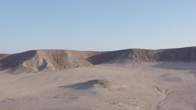 Aerial of the big barchans in the desert with the blue sky and horizon in the background