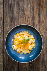 Fruit salad - peaches, pineapples, almonds and corn in mayonnaise on wooden table