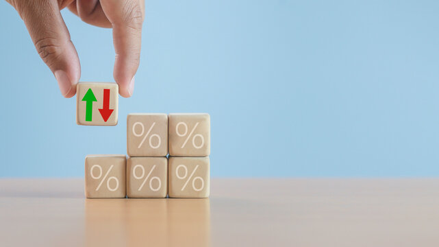 wooden block with percentage sign Marketing business concept, percentage increase-decrease all the time, interest rate decrease, investment reduction and sale discount, blue background.