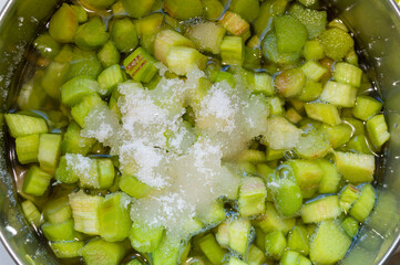 Preparing of rhubarb jam. Chopped rhubarb with sugar in a saucepan