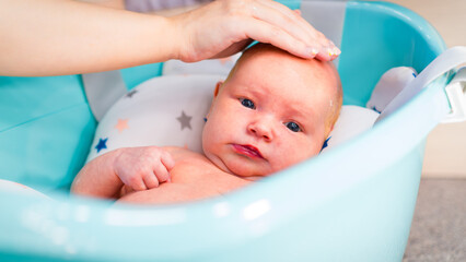 A newborn baby takes a bath. A lovely child is undergoing military training for the first time. The concept of children and hygiene