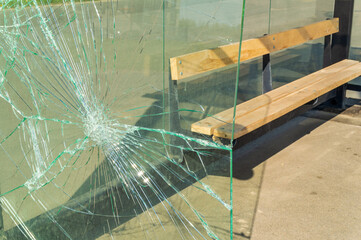 The broken glass wall of the bus stop complex
