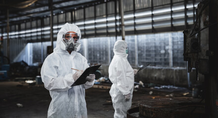 Workers wear protection suit checking chemical in old factory. Protecting Against Hazards and Contamination. Emergency Response to a Radioactive Accident.