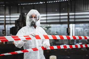 Fototapeta premium Workers wear protection suit checking chemical contaminated oil in old factory. Red and White Lines Marking a Dangerous Zone. Biohazard Contamination Control.