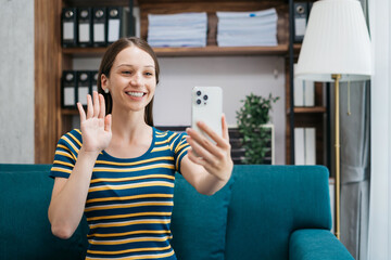 Consulent speaking to mobile cellphone at home office. women speak with remote clients using phone. Laptop on the desk. Home office smart working concept lifestyle.