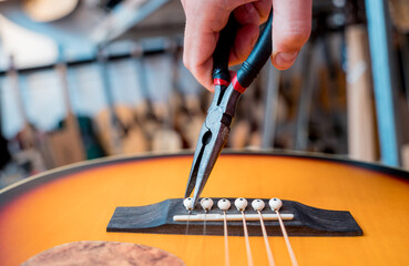 Young musician changing strings on a classical guitar in a guitar shop