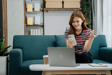 Fototapeta na wymiar Consulent speaking to mobile cellphone at home office. women speak with remote clients using phone. Laptop on the desk. Home office smart working concept lifestyle.