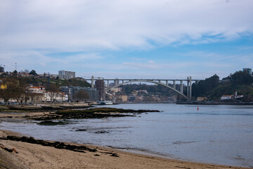 Fototapeta na wymiar la belleza de Oporto, Portugal, con el emblemático puente de Don Luis como protagonista. En la imagen, el puente de hierro se extiende majestuosamente sobre el río Duero, conectando las dos orillas.