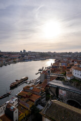 Fototapeta premium Impresionante puesta de sol sobre el río Duero en Oporto, Portugal. Los cálidos rayos dorados del sol poniente pintan el cielo en tonos naranja y rosa, arrojando un brillo impresionante.