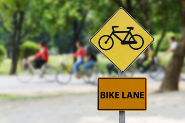 Bicycle lane sign located in green area which is environmental protection area.