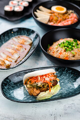 Flatbread with beef and vegetables, rice with chicken, dashi broth, sushi maki rolls with shrimp and calamari.