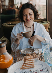 Beautiful girl with a nice smile in a cafe with a cup in her hands