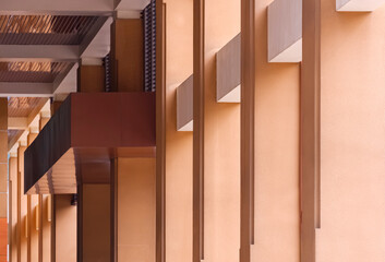 Row of brown concrete rectangular columns in entrance area of modern building in perspective side view 