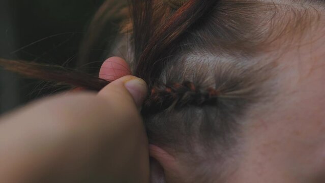 Process of weaving making boxer braids cornrows by a hair braider.