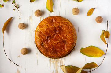 Homemade baked pie served on shabby table with fall leaves and walnuts.autumn composition