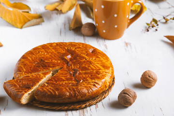 Homemade baked pie served on a shabby table with a cup of tea with autumn leaves and walnuts , autumn composition
