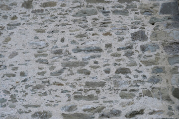 beautiful vintage texture of the wall of a medieval castle built in the middle of the 14th century, multi-colored volumetric stones for the designer, wallpaper, background