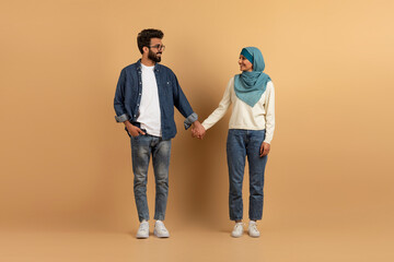 Full length portrait of young muslim couple smiling and looking at each othe