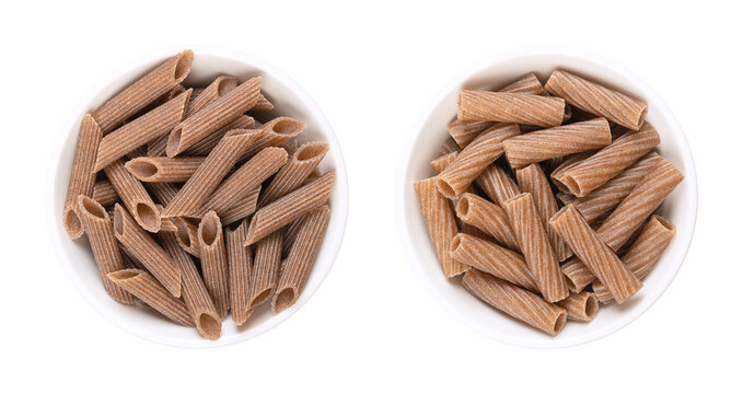 Buckwheat penne and tortiglioni, gluten free whole grain pasta, in white bowls. Brown noodles, made of pure buckwheat semolina, extruded into cylinder-shaped pieces, with ridges to take on more sauce.
