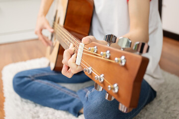 female hands with a guitar close-up, Skillful musician strumming an acoustic guitar,