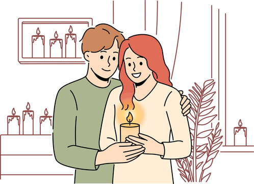 Smiling couple with candle at home