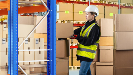 Warehouse supervisor woman. Storekeeper takes box from shelf. Girl in uniform of warehouse worker. Warehouse supervisor. Woman stands among cardboard boxes. Storage company supervisor