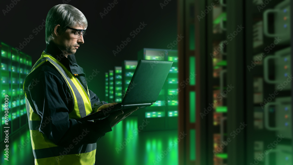 Poster man in server room. system administrator with laptop. guy works for hosting company. data center. ma