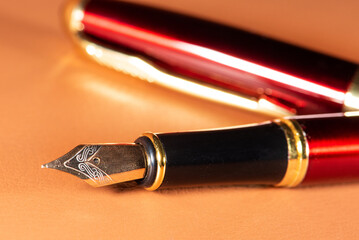 Fountain pen, beautiful details of a fountain pen on a leather surface, selective focus.