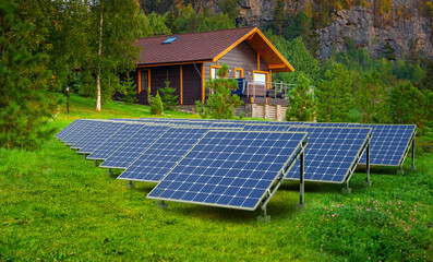 House with solar panels. Cottage among trees. Housing in eco clean place. Solar panels on lawn. Eco...