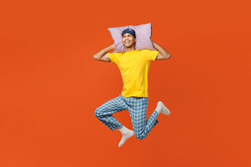 Full body calm young young man wears pyjamas jam sleep eye mask rest relax at home jump high hold...