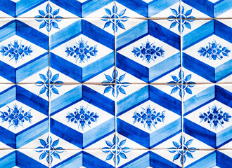 Typical tiles with blue and white rhomboidal shapes and floral themes, adorning the facades of the houses in Porto, Portugal
