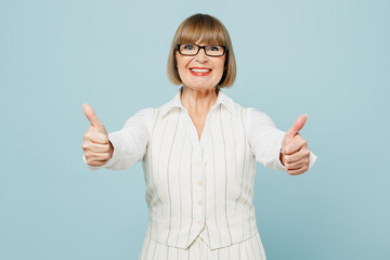 Blonde successful employee business woman 50s wear white classic suit glasses formal clothes showing thumb up like gesture isolated on plain pastel light blue background. Achievement career concept.