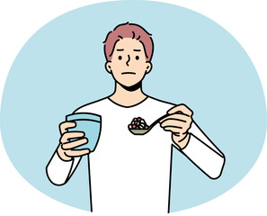 Man with spoonful of pills having medications