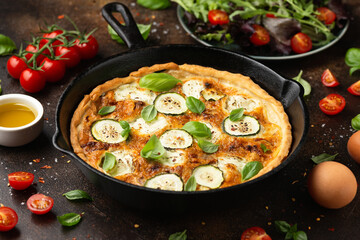 Sun baked tomato, goats cheese and courgette quiche served in cast iron pan with side salad