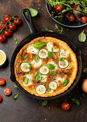 Sun baked tomato, goats cheese and courgette quiche served in cast iron pan with side salad