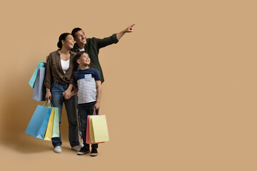 Adorable black family shopping together, looking at copy space