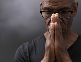 black man praying to god with hands together Caribbean man praying stock photo	